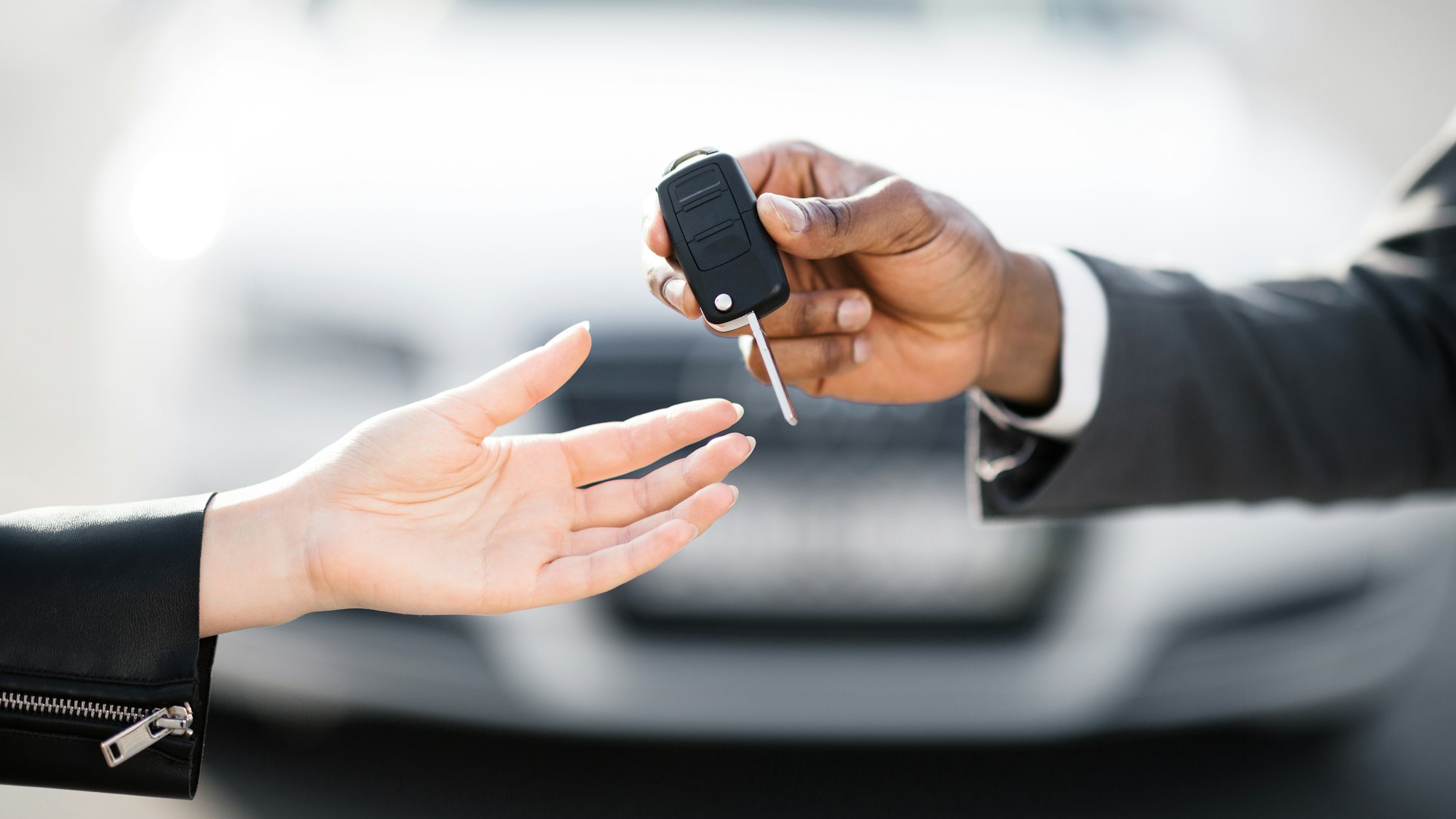 Car sale. Dealer giving key to new owner
